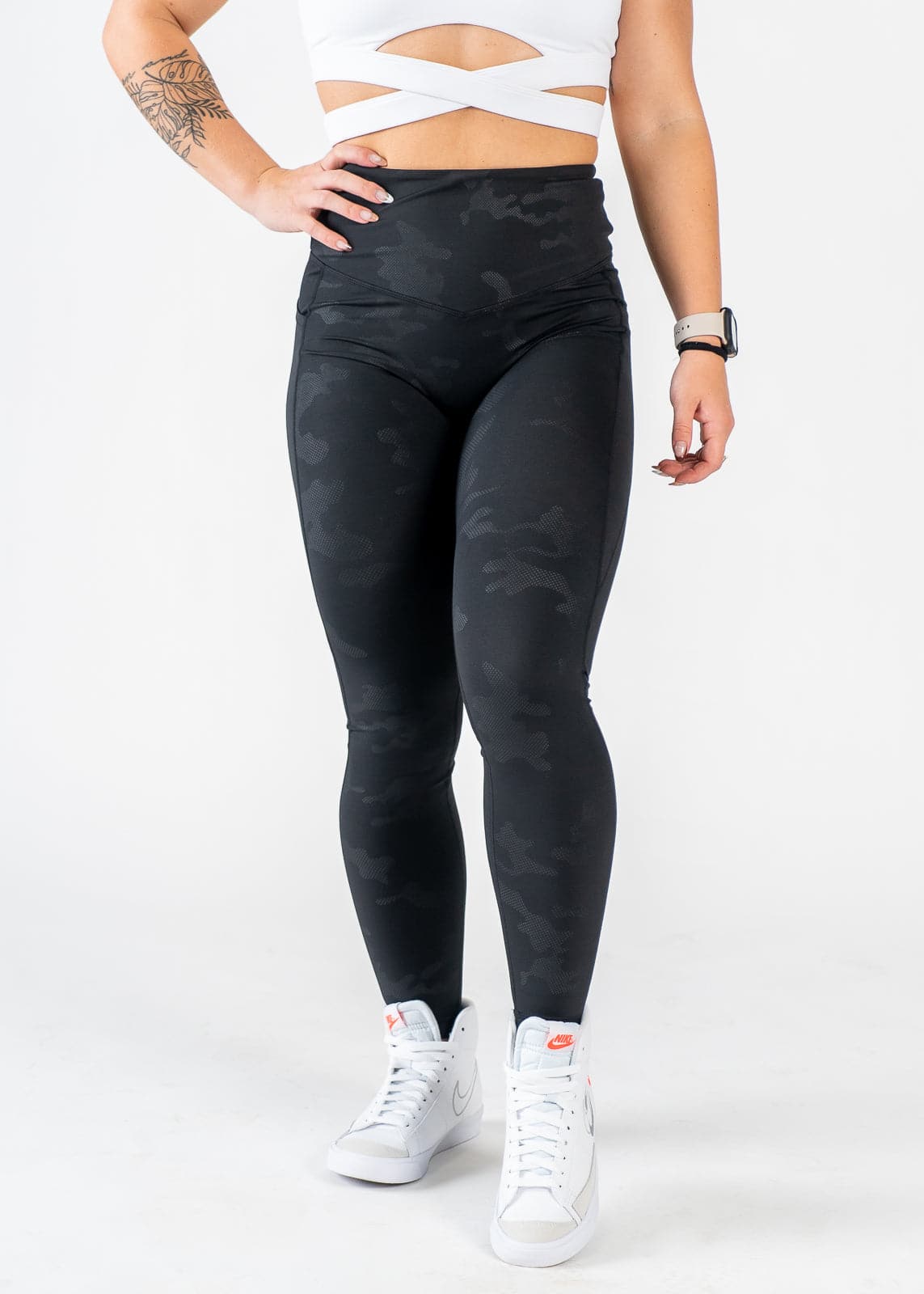 Chest Down Front View One Hand on Hip Wearing Empowered Leggings x FIT OPS | Black Camo
