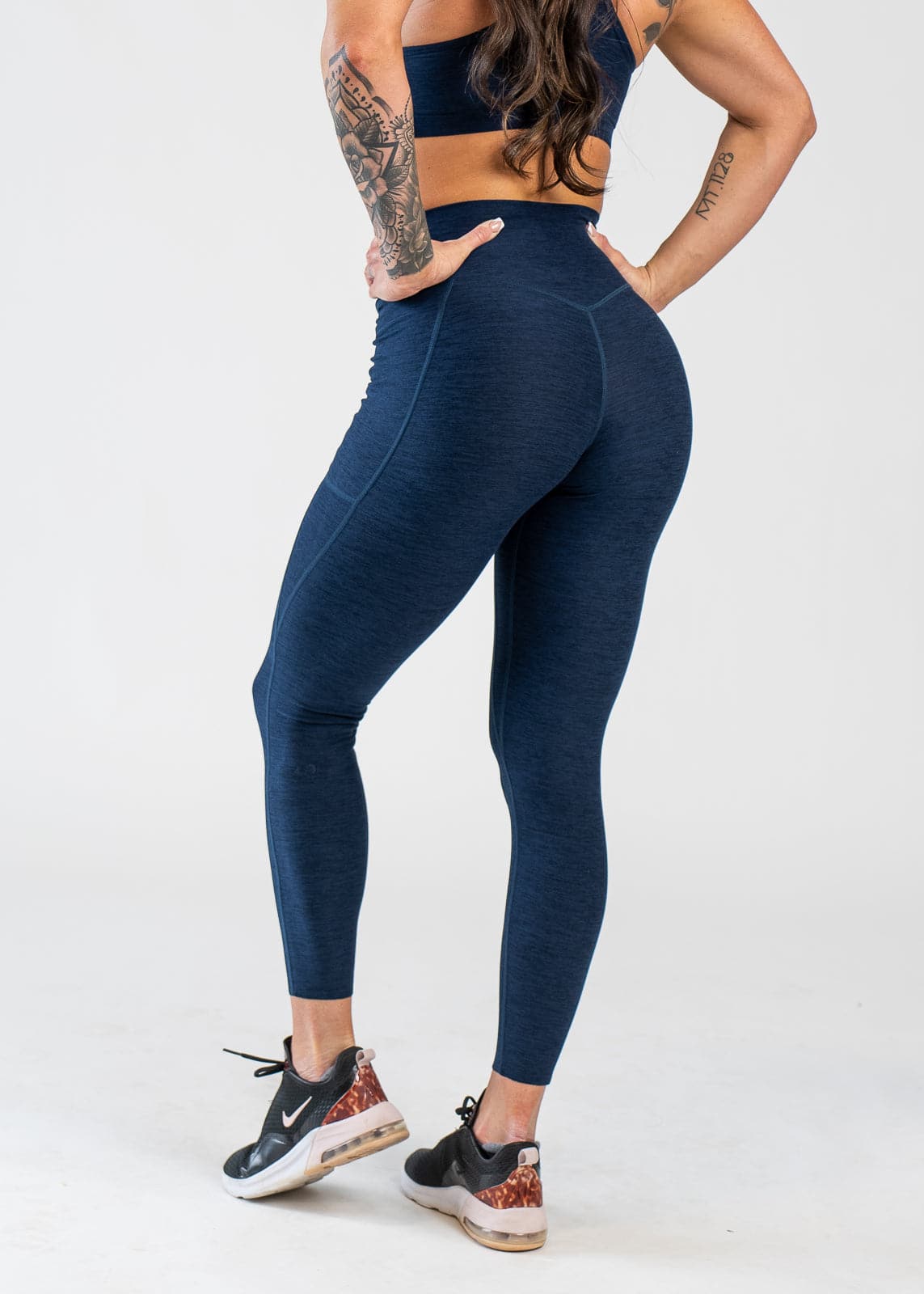 Chest Down 3/4 Back View With Hands on Hips Wearing Dream Leggings With Pockets | Deep Blue