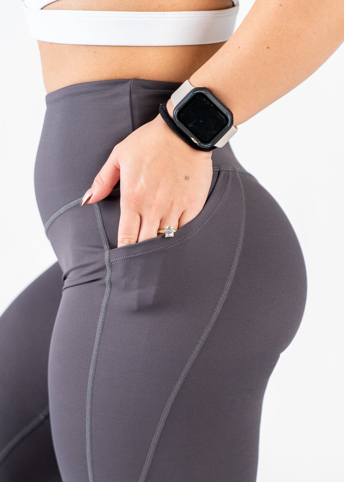 Chest to Thigh Side View with Hand in Pocket Wearing Empowered Leggings x FIT OPS | Grey