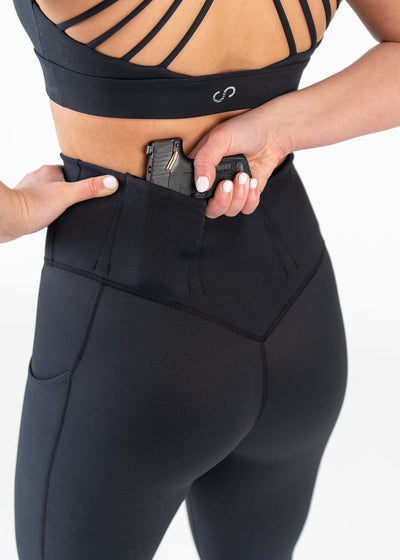 Concealed Carry Leggings With Pockets Shoulders Down Back View Close Up Reaching for Concealed Carry | Black