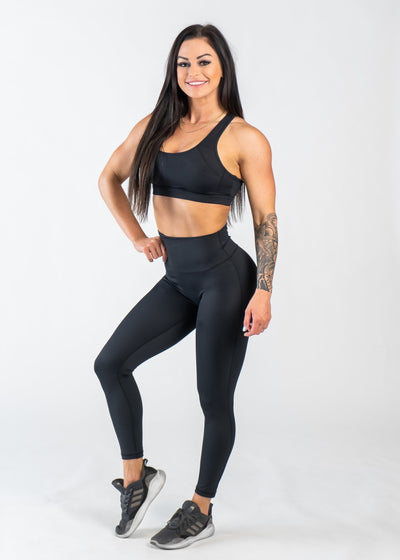 Full Body 3/4 Front Pose with One Leg Bent and One Arm on Hip Wearing Empowered Leggings | Black