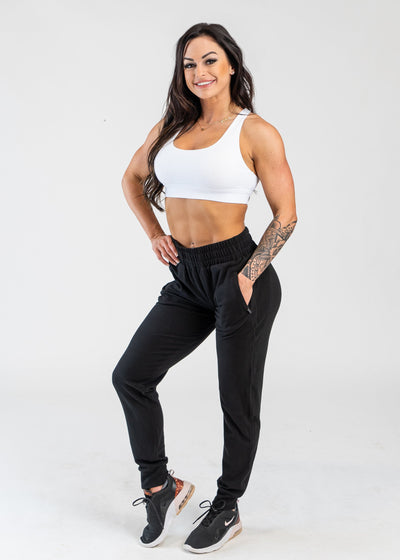 Full View Woman Wearing White Crop Bra and Black Boyfriend Joggers Front 3/4 View
