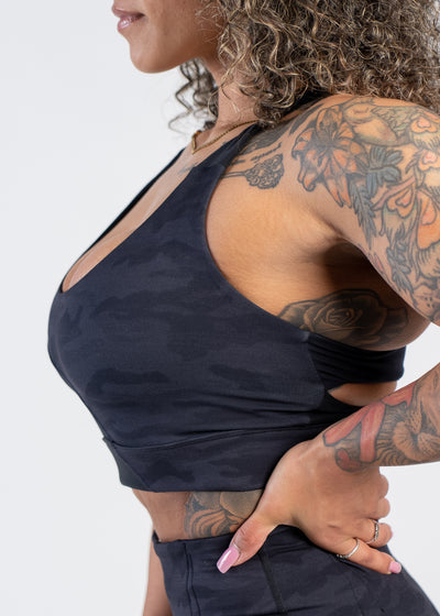 Side View Chin to Waist with Hand on Lower Back Wearing Empowered Double Brushed Bra | Black Camo