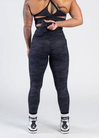 Concealed Carry Leggings With Pockets Shoulders Down Back View Reaching for Concealed Carry | Black Camo
