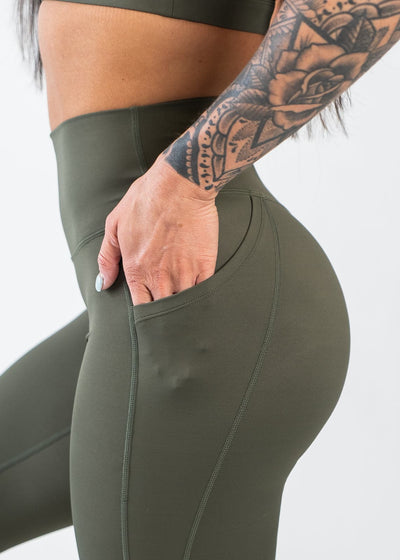 Chest to Thigh Side View with Hand in Pocket Wearing Empowered Leggings With Pockets | OD Green