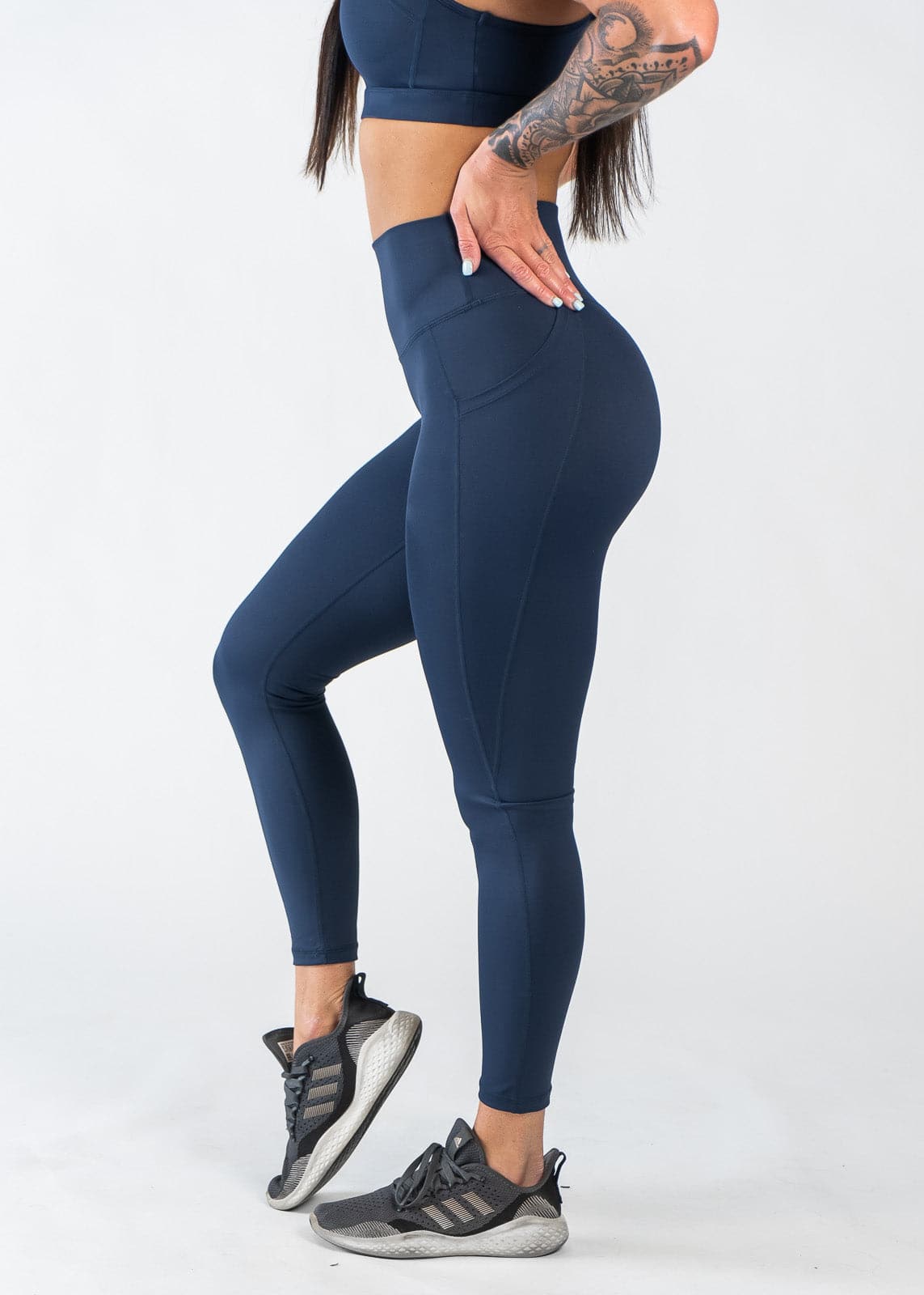 Chest Down Side View One Leg Up Wearing Empowered Leggings With Pockets | Blue