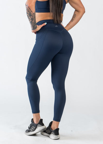 Chest Down 3/4 Back View with Hands on Hips Wearing Empowered Leggings With Pockets | Blue
