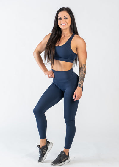 Full Body 3/4 Front View One Leg Up Wearing Empowered Leggings With Pockets | Blue
