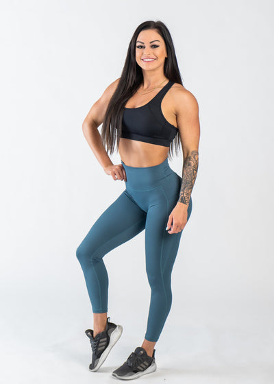 Full Body 3/4 Front View One Leg Up Wearing Empowered Leggings With Pockets | Teal