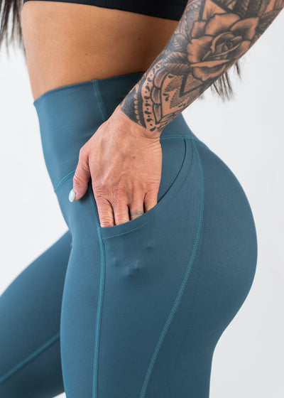 Chest to Thigh Side View with Hand in Pocket Wearing Empowered Leggings With Pockets | Teal
