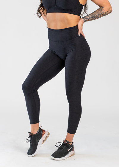 Chest Down 3/4 Front View With One Hand on Lower Back Wearing Dream Leggings | Black