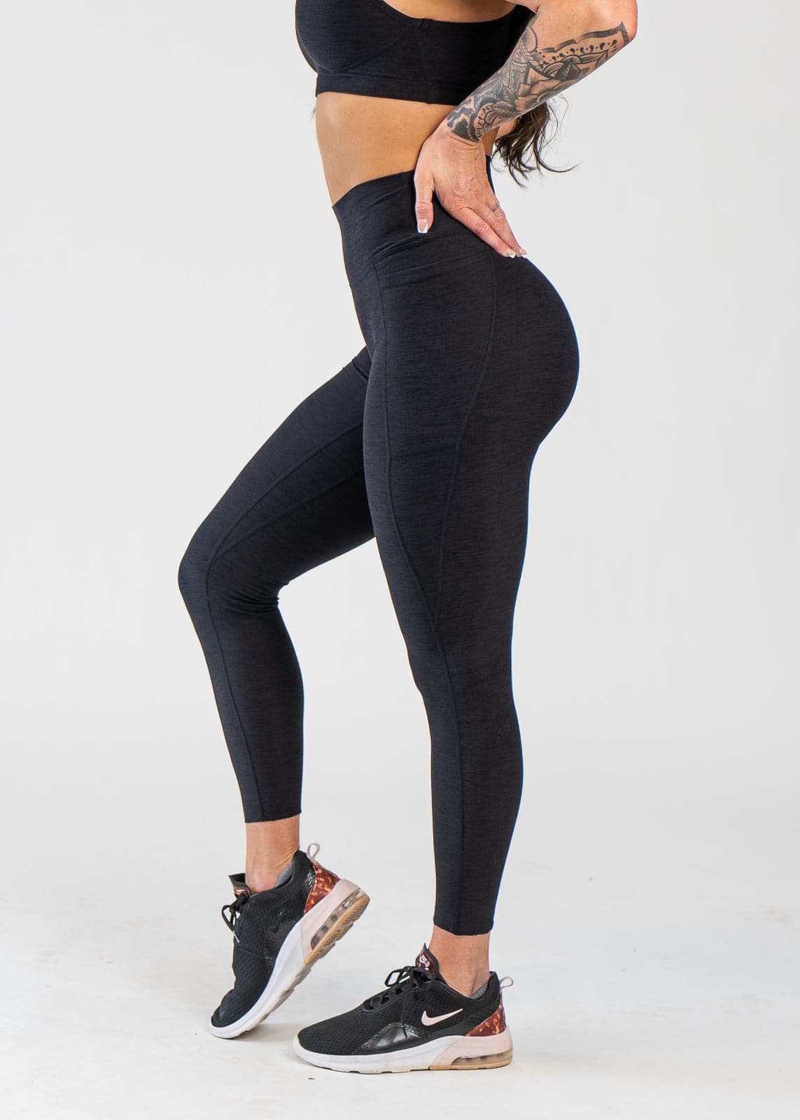 Chest Down Side View With One Hand on Lower Back Wearing Dream Leggings With Pockets | Black