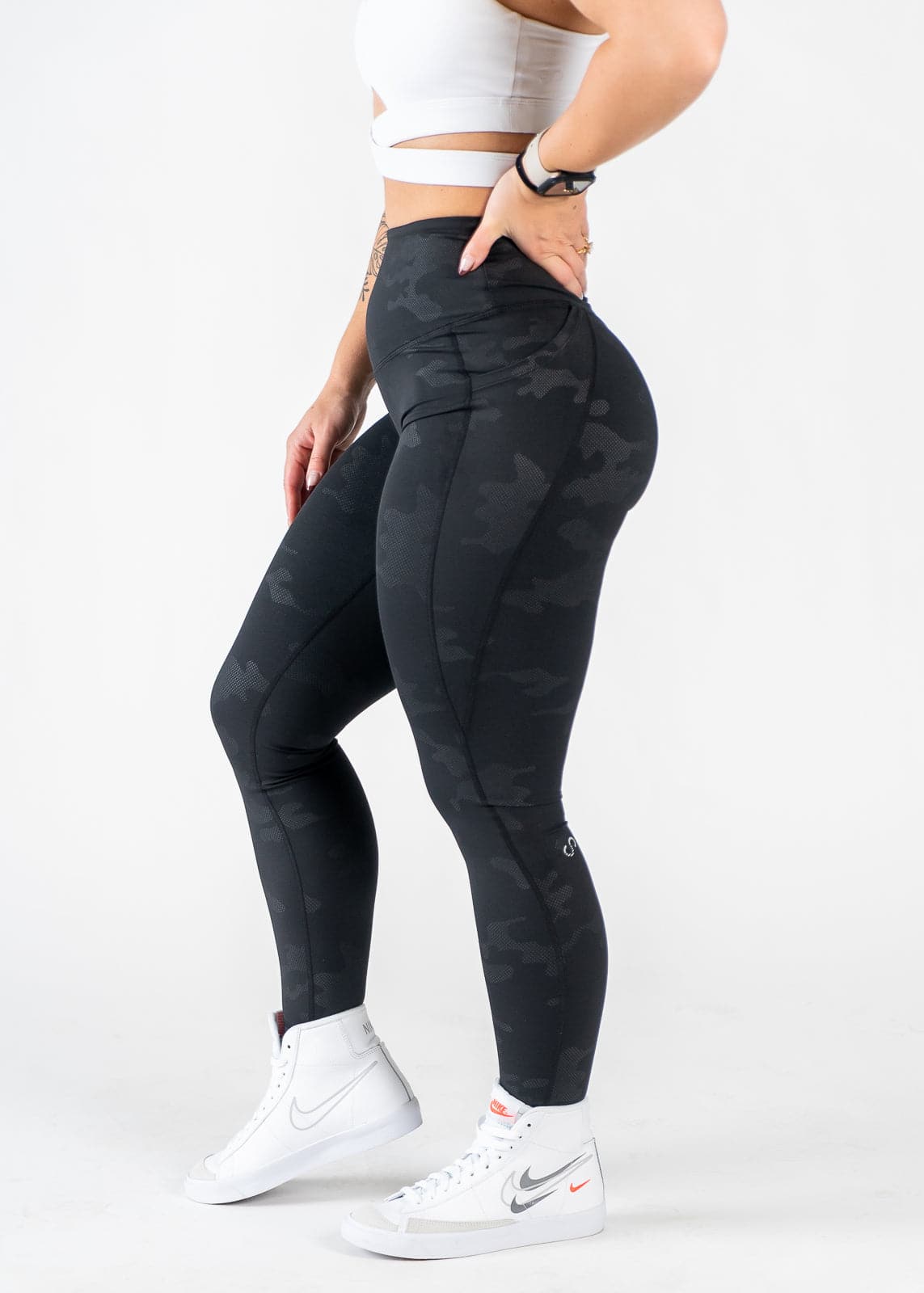 Chest Down Side View One Leg Up Wearing Empowered Leggings x FIT OPS | Black Camo