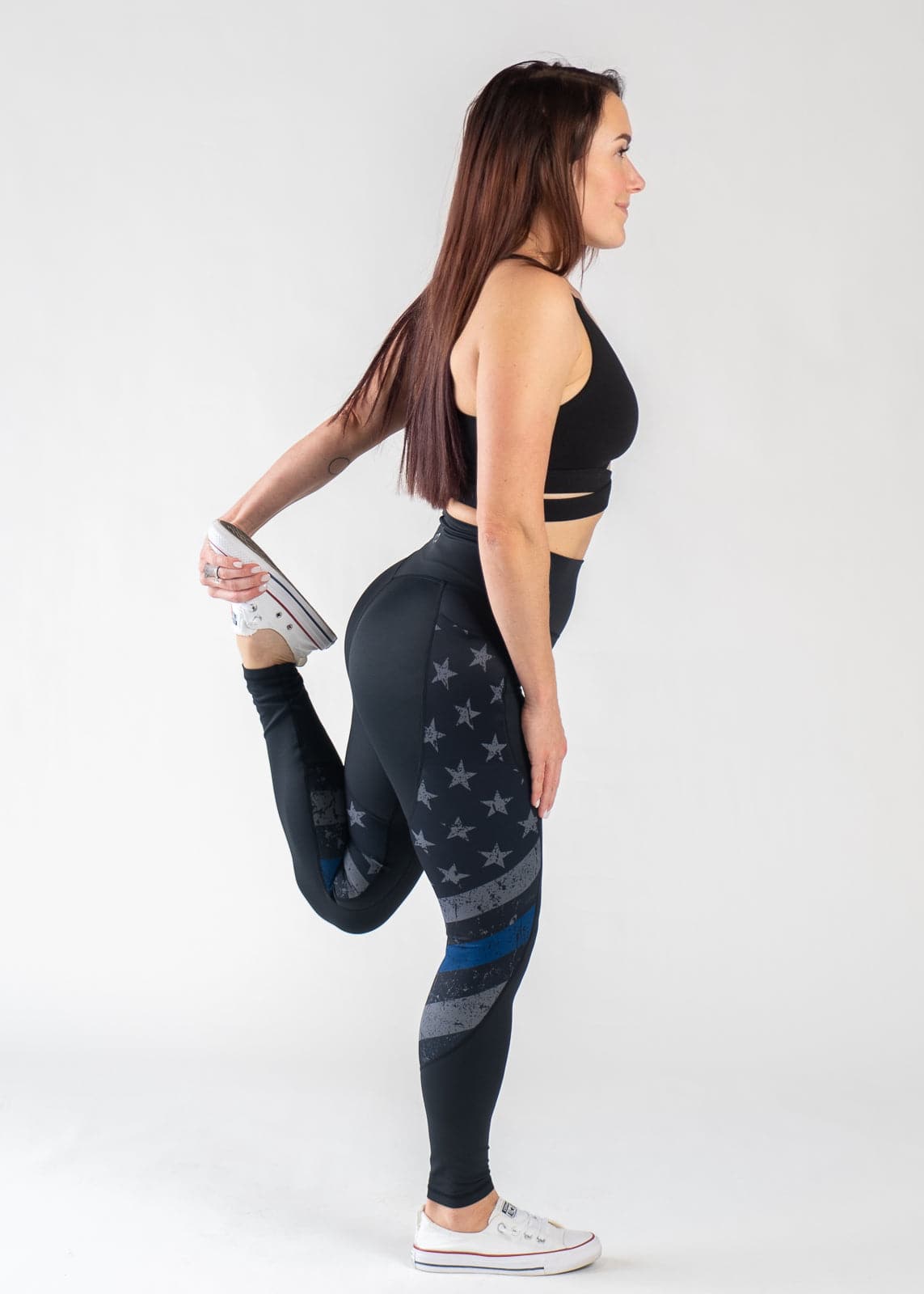 Full Body Side View Performing a Quad Stretch Wearing Empowered Leggings | Blue Line