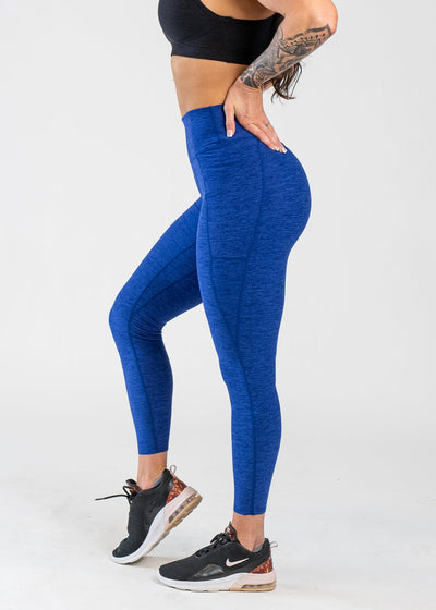 Chest Down Side View With One Hand on Lower Back Wearing Dream Leggings With Pockets | Blue Razz