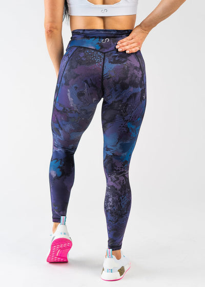 Waist Down Back View with One Hand on Lower Back Wearing Empowered Leggings | Galaxy