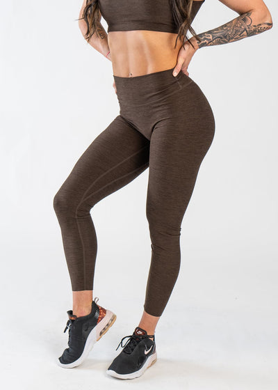 Chest Down 3/4 Front View With One Hand on Lower Back Wearing Dream Leggings | Cocoa