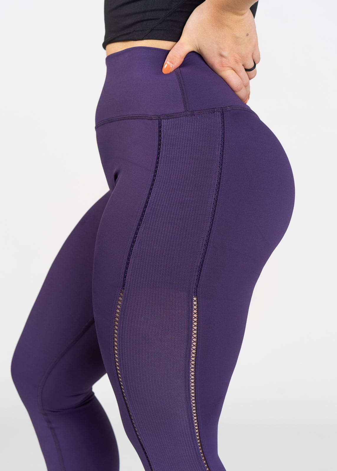 Chest to Shin Side View With Hands on Lower Back Wearing Empowered Leggings With Cut Outs | Purple