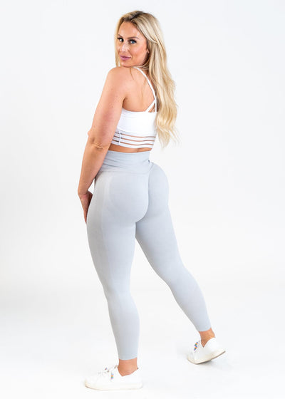 Full Body Back View Woman Looking Back Over Her Left Shoulder in Contour Seamless Leggings - Ice