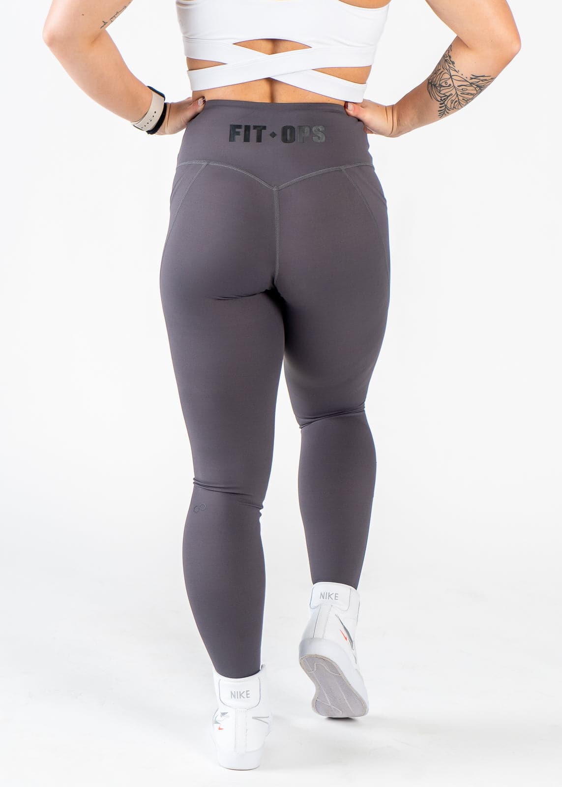 Chest Down Back View Hands on Hips Wearing Empowered Leggings x FIT OPS | Grey