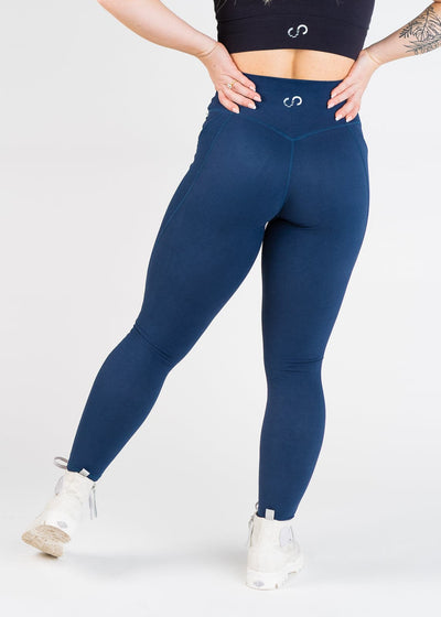 Shoulders Down Back View Hands on Hips With One Leg Out Wearing Empowered Double Brushed Leggings - Navy Blue