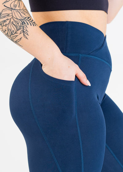 Chest to Knees Side View Close Up with One Hand in Pocket Wearing Empowered Double Brushed Leggings - Navy Blue