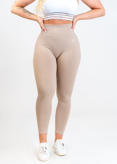 Shoulders Down Front View in Contour Seamless Leggings with Hands on Lower Back - Shell