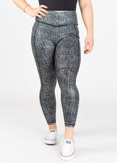 Chest Down Front View with One Hand on Hip Wearing Empowered Leggings With Pockets | Black/Silver