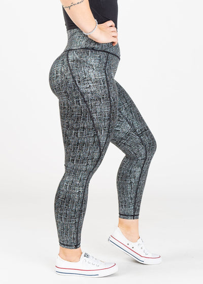 Chest Down Side View One Leg Up Wearing Empowered Leggings With Pockets | Black/Silver