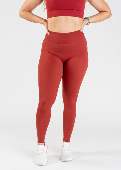 Chest Down Front View With Hands On Hips Wearing Empowered Double Brushed Leggings - Rust Red